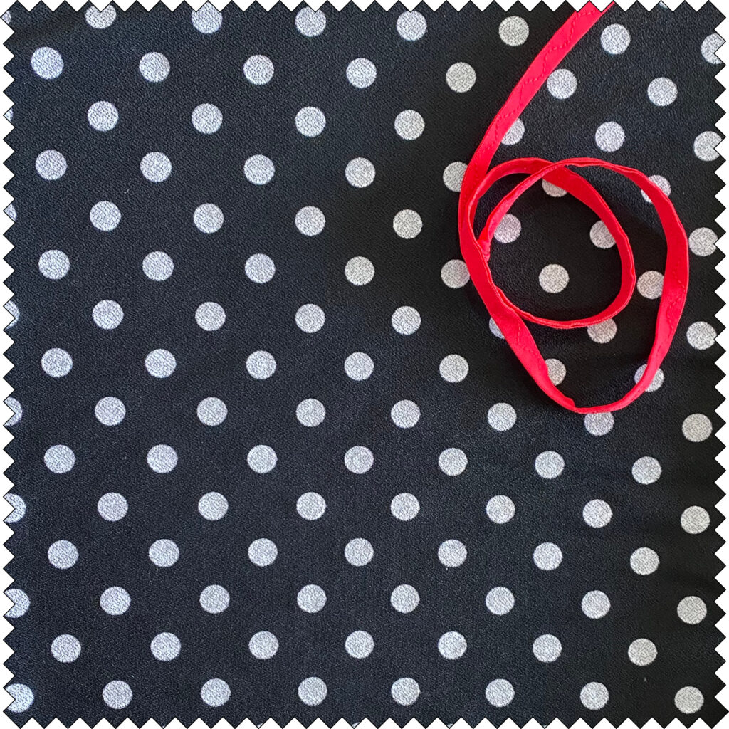 Polka dot in polyester jersey - with a striking red trim
